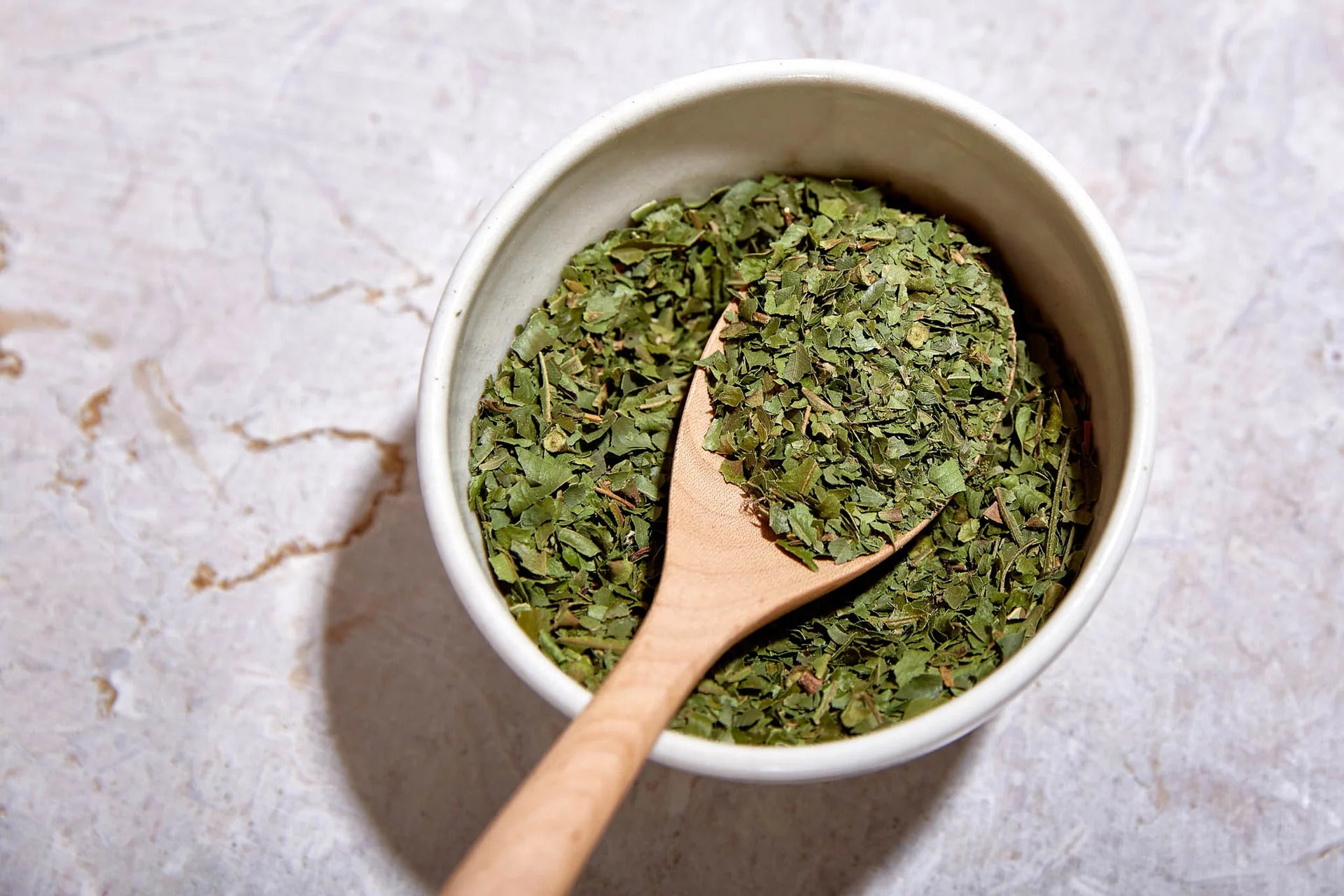 Ground Anise myrtle in pot with wooden spoon